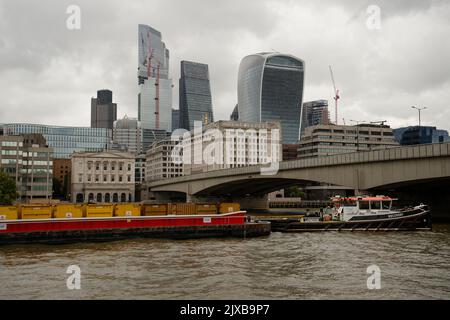 La ville de Londres avec des barges chargées de conteneurs sur la Tamise. La traction du remorqueur est appelée récupération. Banque D'Images