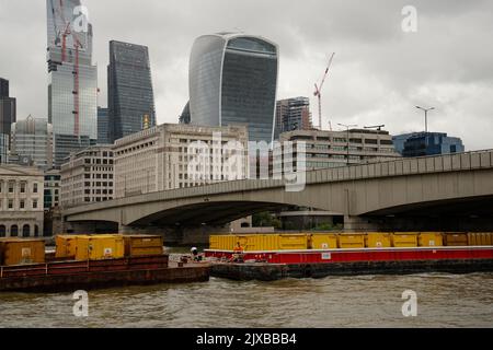 La ville de Londres avec des barges chargées de conteneurs sur la Tamise. Banque D'Images