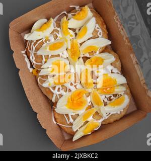 Pâtisserie indienne en-cas dans une boîte avec des œufs à ébullition sombre fond de photographie studio Banque D'Images