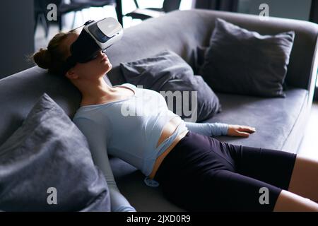 Robot comme une poupée futuriste femme dans la réalité virtuelle masque interface sur la tête entre dans l'expérience réaliste métaverse via le casque. Aspect créepeux Banque D'Images