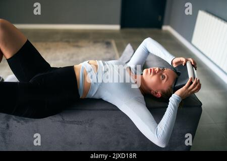 Robot comme une poupée futuriste femme dans la réalité virtuelle masque interface sur la tête entre dans l'expérience réaliste métaverse via le casque. Aspect créepeux Banque D'Images