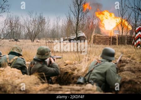 Les réacteurs ont armé des fusils et se sont habillés comme soldats allemands de l'infanterie Wehrmacht de la Seconde Guerre mondiale combattant de manière défésive dans le Trench. Position défensive. Lutte Banque D'Images