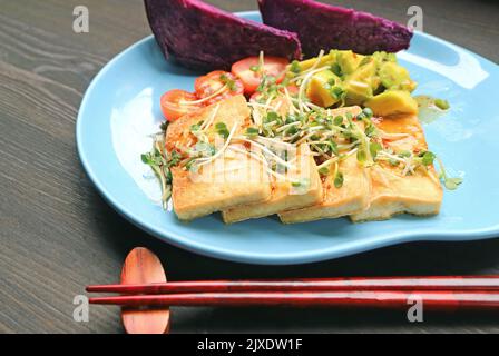 Délicieux tofu grillé et salade de microlégumes Daikon frais avec pommes de terre sucrées violaises cuites à la vapeur Banque D'Images