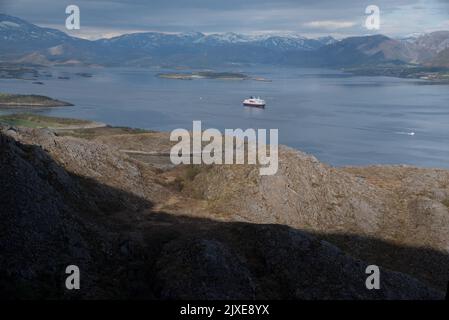 Hurtigrluten navire Kong Harald passant le dôme de granit de Torghatten dans le centre de la Norvège tout en quittant Brønnøysund. Banque D'Images