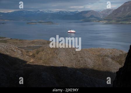 Hurtigrluten navire Kong Harald passant le dôme de granit de Torghatten dans le centre de la Norvège tout en quittant Brønnøysund. Banque D'Images