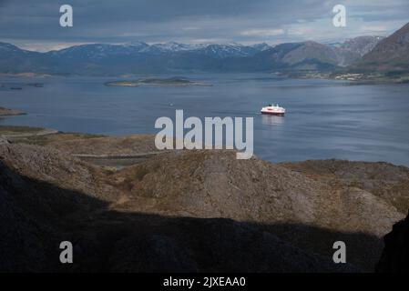 Hurtigrluten navire Kong Harald passant le dôme de granit de Torghatten dans le centre de la Norvège tout en quittant Brønnøysund. Banque D'Images