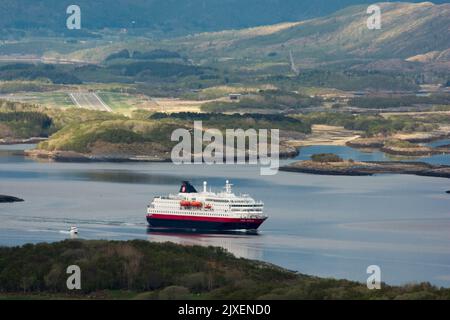 Hurtigrluten navire Kong Harald passant le dôme de granit de Torghatten dans le centre de la Norvège tout en quittant Brønnøysund. Banque D'Images