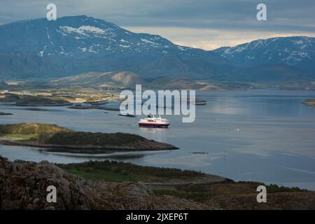 Hurtigrluten navire Kong Harald passant le dôme de granit de Torghatten dans le centre de la Norvège tout en quittant Brønnøysund. Banque D'Images