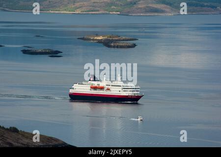 Hurtigrluten navire Kong Harald passant le dôme de granit de Torghatten dans le centre de la Norvège tout en quittant Brønnøysund. Banque D'Images