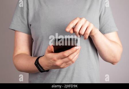 Femme avec bracelet de fitness au poignet utilisant l'application mobile au téléphone pour vérifier la fréquence cardiaque, la qualité du sommeil, les résultats d'activité physique. Une vie saine Banque D'Images