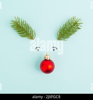 Visage d'un renne avec un nez de boule rouge, des bois de sapin et des yeux amicaux, carte de vœux de joyeux noël Banque D'Images