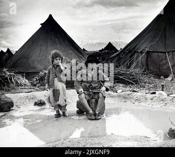 La photographie montre deux enfants qui regardent leurs tentes familiales après que presque toutes leurs possessions ont été lavées pendant les inondations à Tripoli, au Liban. Daté du 20th siècle Banque D'Images