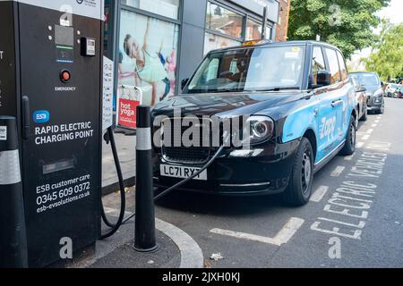 Londres - 2022 août : taxi électrique de Londres à un point de charge électrique rapide de Streatham High Road dans le sud-ouest de Londres Banque D'Images