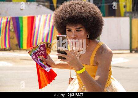 Goias, Brésil – 04 septembre 2022 : une personne aux cheveux noirs puissants, photographiant à l'aide d'un téléphone portable. Photo prise lors de la LGBTQIA+ Pride Banque D'Images