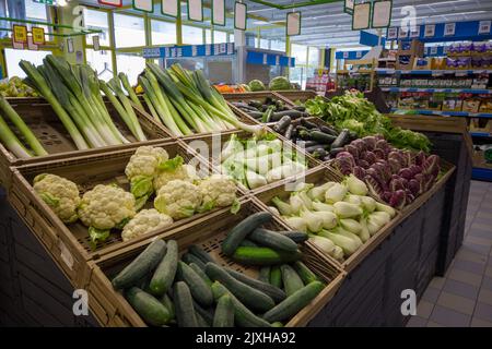 Fossano, Italie - 30 août 2022: Étals avec légumes dans le supermarché italien Eurospin, concombre, chou, poireau, fenouil et salade dans des boîtes exposées Banque D'Images