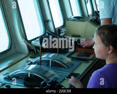 Russie, Sotchi 12.06.2022. Cabine du capitaine du navire. Une petite touriste dans la cabine du capitaine regarde par la fenêtre Banque D'Images