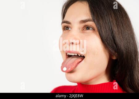 Femme à bouche ouverte avec des pilules sur la langue sur fond blanc avec espace pour le texte Banque D'Images