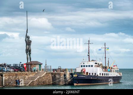 Le navire de ravitaillement et le navire à passagers MV Oldenburg amarrés le long du quai, avec la célèbre statue de Damien Hirst Verity en arrière-plan Banque D'Images