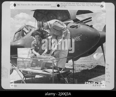 1st Lt H.A. sang examinant des munitions chargées dans le 'BABE' Lockheed P-38 du groupe de chasseurs 14th. Banque D'Images