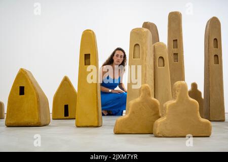 Londres, Royaume-Uni. 7 septembre 2022. Un membre du personnel pose avec des sculptures en cire d'abeille sous forme de tours, maisons et ziggurats faisant référence à l'architecture du Moyen-Orient, de l'Inde et de l'Asie du Sud-est à l'avant-première de "City of Silence", une nouvelle exposition de l'artiste allemand Wolfgang Laib, à la galerie Thaddaeus Ropac de Mayfair. L'exposition se déroule du 8 septembre au 3 octobre 2022. Credit: Stephen Chung / Alamy Live News Banque D'Images