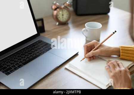 étudiante asiatique regardant la leçon en ligne et étudiant à distance. La jeune femme prend des notes, écoutant la conférence de l'enseignante sur appel vidéo.Video Banque D'Images