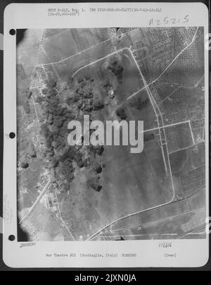 Des explosions de bombes couvrent des installations à l'aérodrome de Grottaglie (Italie), le 30 juillet 1943, lors d'une attaque par des avions du 2nd Bomb Group, 20th Bomb Squadron, 15th Air Force. Banque D'Images