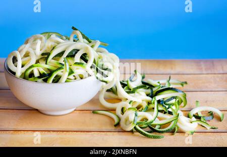 Un bol rempli de courgettes ou de courgettes spiralisées. Utilisé comme une alternative de régime Keto aux spaghettis et connu sous le nom de courgetti, nouilles de courgettes ou zoodles Banque D'Images