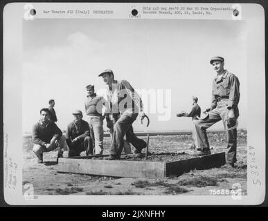 Les membres du 94th Fighter Squadron, 1st Fighter Group, profitent D'Une partie de fers à cheval pendant leurs heures de travail à un aérodrome quelque part en Italie. Banque D'Images