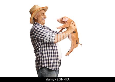 Joyeux fermier mûr tenant un petit cochon et souriant isolé sur fond blanc Banque D'Images