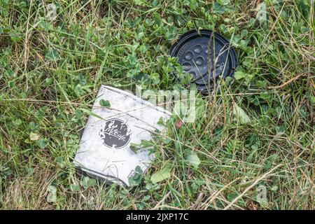 Tasse à café McCafe à emporter mise au rebut sur le bord de l'herbe par un automobiliste. Incertain si le gobelet est en papier ou en plastique laminé. McCafe lié à McDonalds. Banque D'Images