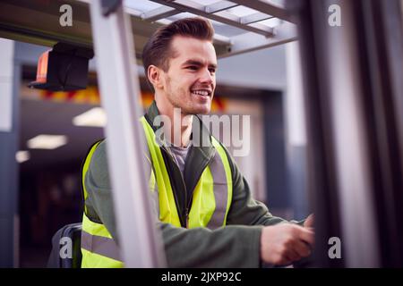 Travailleur masculin exécutant un chariot élévateur à fourche dans le secteur transport de marchandises Banque D'Images