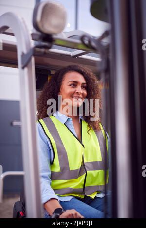 Femme qui travaille sur un chariot élévateur à fourche dans le secteur transport de marchandises Banque D'Images