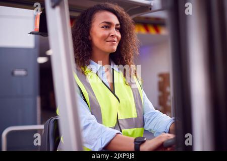 Femme qui travaille sur un chariot élévateur à fourche dans le secteur transport de marchandises Banque D'Images