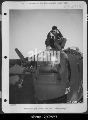 À PARTIR D'UNE BASE DE BOMBARDIER LOURDE À FORCE AÉRIENNE DE 15TH. ... 10 janvier 1944. .. Consolidated B-24 Liberator Navigator, 2nd Lt. Joseph P. Orley de Napoléon, N.D., examine les trous dans sa tourelle nasale au retour d'un attentat à la bombe sur l'aérodrome à Banque D'Images