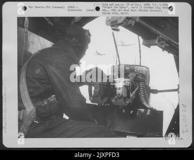 Volant à la cible, quelque part en Allemagne, le Bombardier Mans le fusil de nez alors qu'il regarde pour les combattants ennemis. La formation entre maintenant dans le territoire ennemi et les hommes dans chaque avion scrutent les Skies pour Messerschmitts, Fockewulfs et Heinkels. Banque D'Images