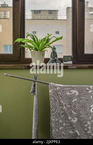 Linge de lit sur le sèche linge avec tempurature numérique et capteur d'humidité sur le balcon par temps de pluie Banque D'Images