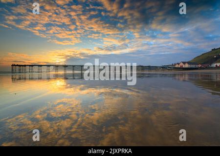 Saltburn Pier capturé peu après le lever du soleil de la plage. Banque D'Images