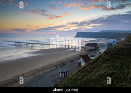 Saltburn Pier et la plage capturées au lever du soleil depuis un point de vue élevé. Banque D'Images