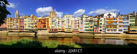 Vue panoramique sur les maisons pittoresques et colorées à côté de la rivière Onyar en traversant la vieille ville de Gérone, Catalogne, Espagne. Banque D'Images