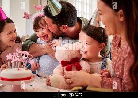 Famille avec le syndrome de Down fille célébrant anniversaire avec la fête à la maison ensemble Banque D'Images