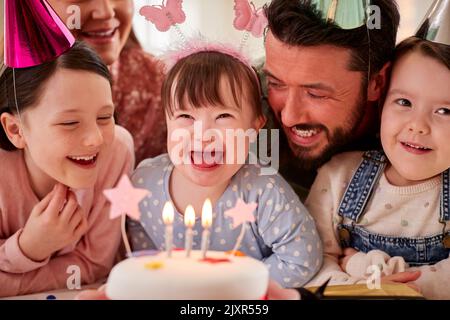 Famille avec le syndrome de Down fille célébrant anniversaire avec la fête à la maison ensemble Banque D'Images