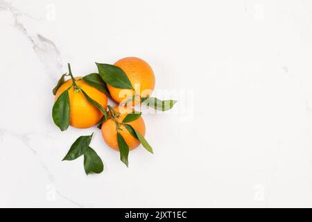 Oranges avec feuilles vertes sur un comptoir de cuisine en marbre Banque D'Images