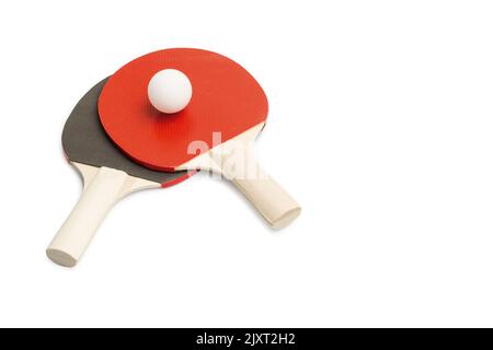 Palettes de ping-pong rouges et noires avec une balle blanche sur fond blanc avec espace de copie Banque D'Images