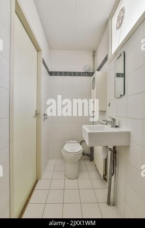 Toilettes et cabine de douche à chasse d'eau avec rideau situé près du lavabo et du miroir dans les toilettes Banque D'Images