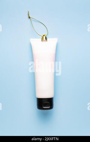 Bouteille en tube blanc Mockup soin du visage sur fond bleu, décoration cosmétique pour les fêtes. Concept. Banque D'Images