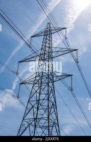 Vue au niveau du sol d'un pylône électrique avec câbles haute tension lors d'une journée d'été claire dans la campagne de Hertfordshire en Angleterre Banque D'Images
