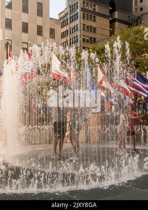 Personnes dans les fontaines d'eau lors d'une chaude journée d'été à Manhattan, New York, États-Unis Banque D'Images