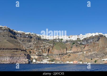 Fira, Santorini, Grèce - juin 2022 : vue panoramique sur le front de mer et la ville de Fira au sommet des hautes falaises Banque D'Images