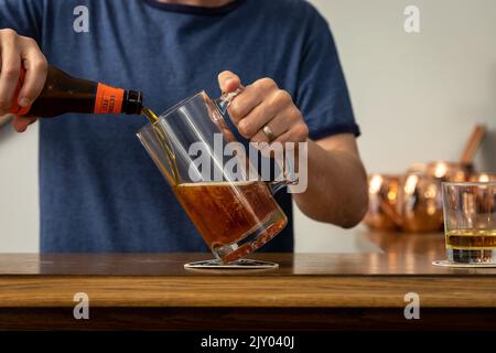 Homme versant de la bière dans un verre Stein à un bar Banque D'Images