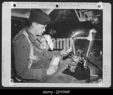 Lieutenant J.E. McLain, Pueblo, Colorado, Bombardier à bord de l'bombardier B-17 « Forteresse volante » de Boeing, « le moniteur », regarde les commandes de canon de Chin Turret qui ont été écrasées par Flak entrant dans le navire par le bec en verre de Plexi. Les flexibles ont été bloqués sur le passage Banque D'Images